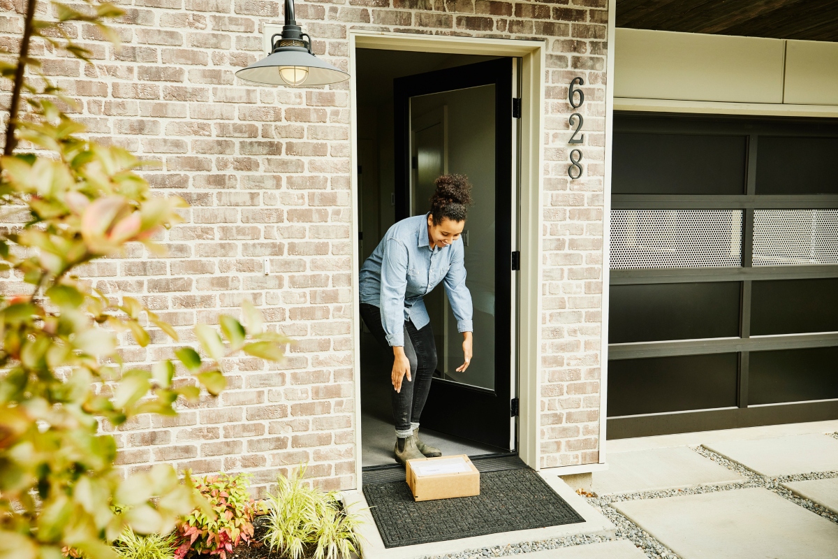 woman picking up a package on her front porch