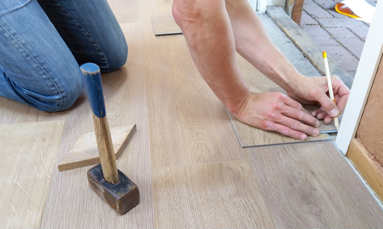 person measuring floor with pencil
