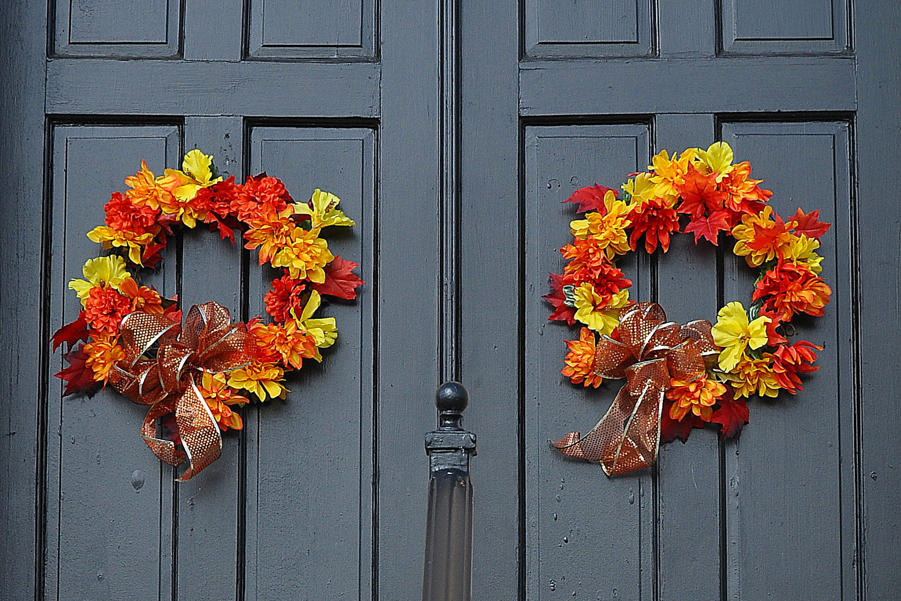 Two autumn leaf wreaths on a front door