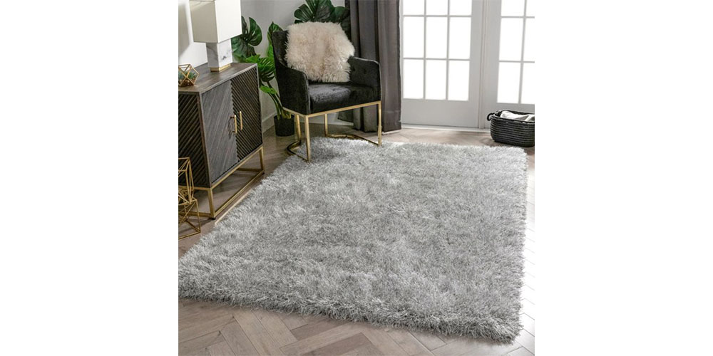 Well Woven Kuki Chie Glam Solid Textured Rug placed on a living room floor.