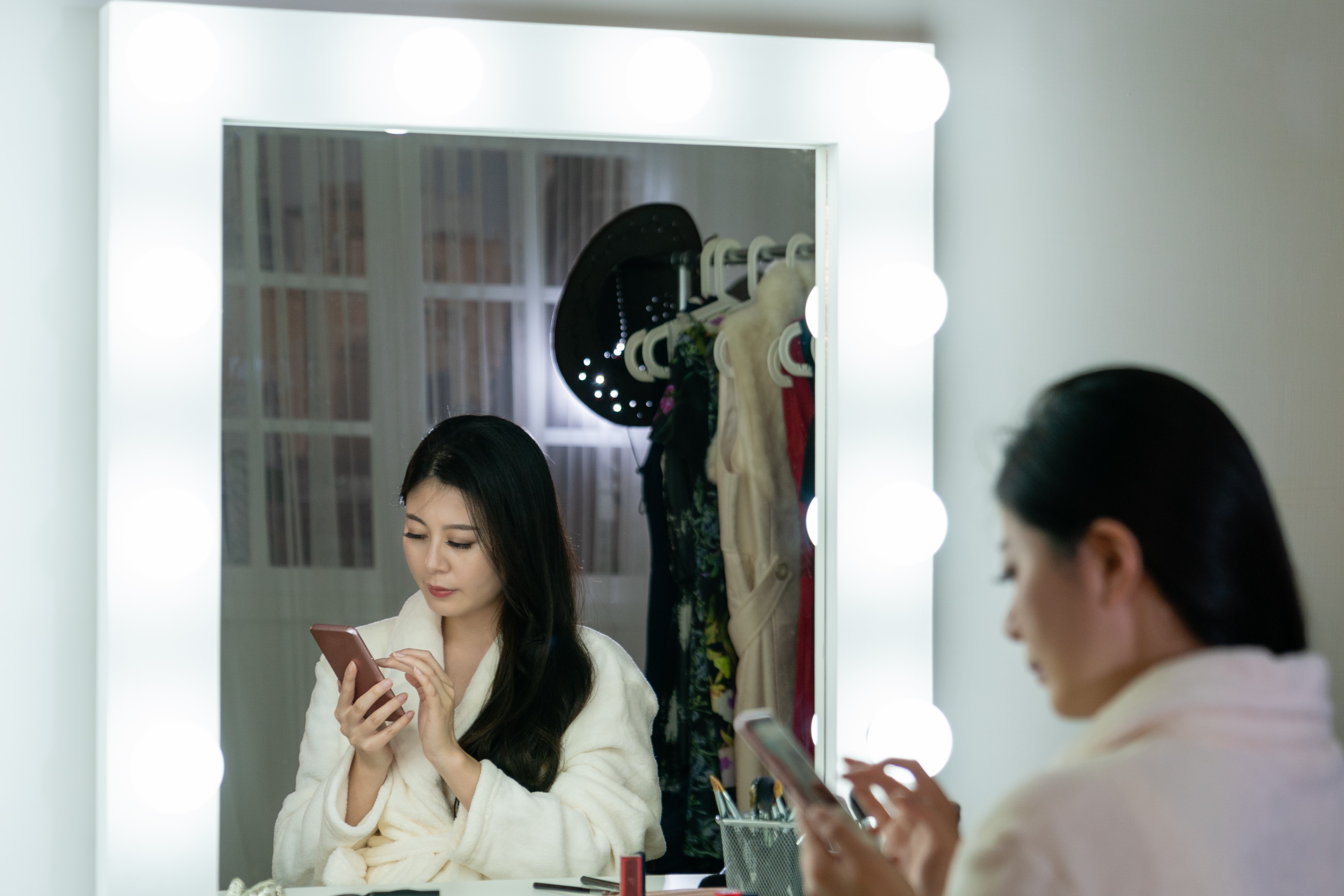 Young woman sitting at a vanity in a walk-in closet