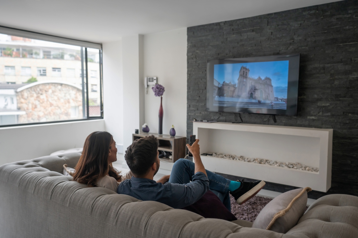 couple sitting on couch watching tv with surround sound