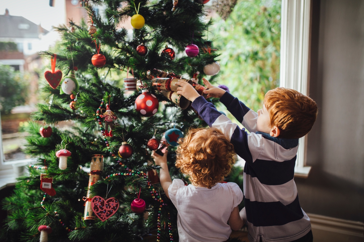 kids putting up christmas tree decorations
