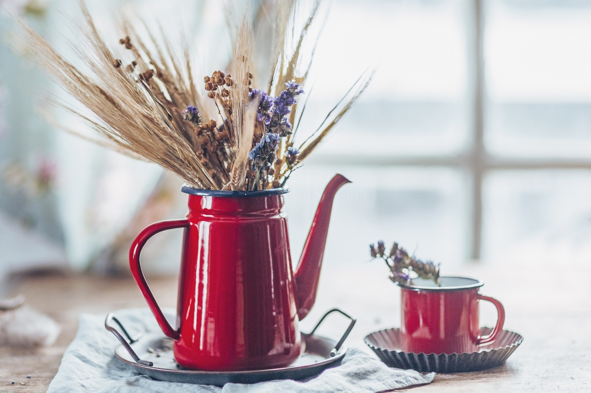 red teacup and kettle decor with brown grass in them