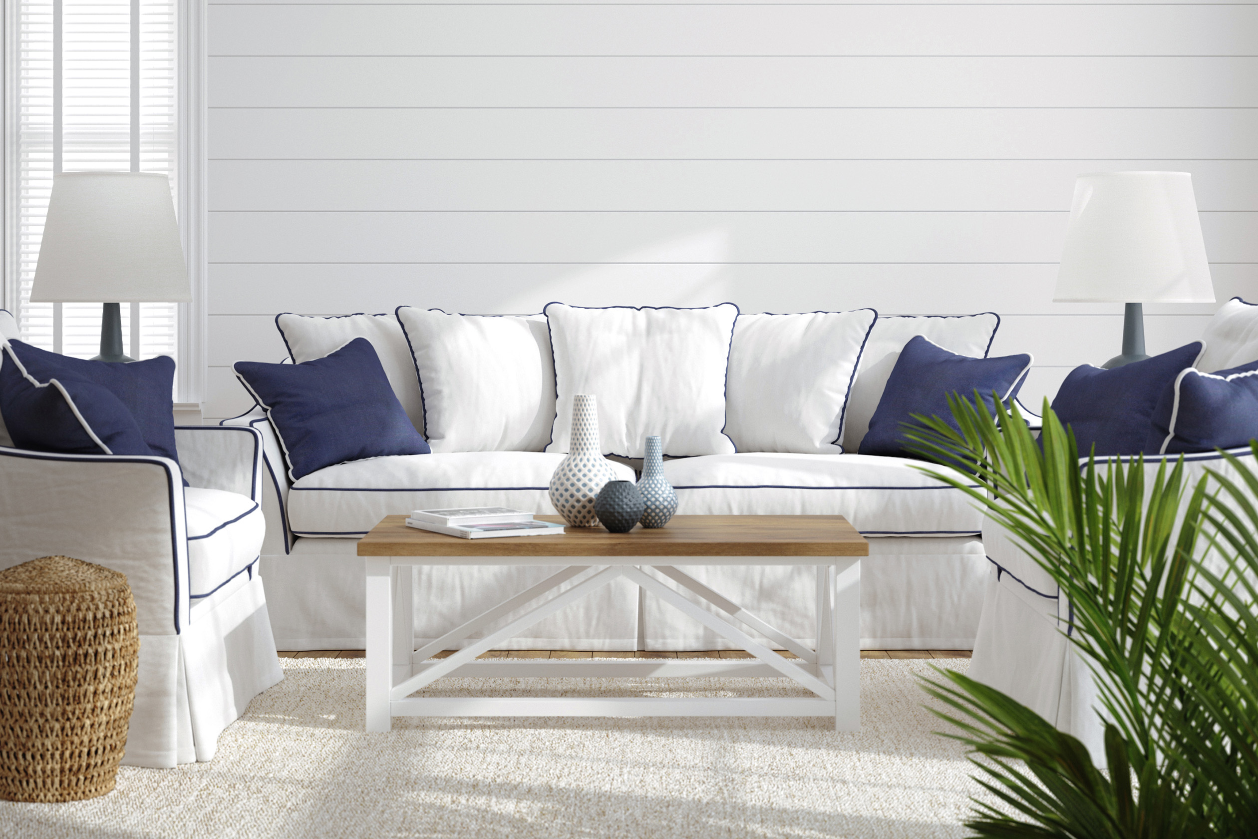 White sofa with navy accents in front of shiplap wall