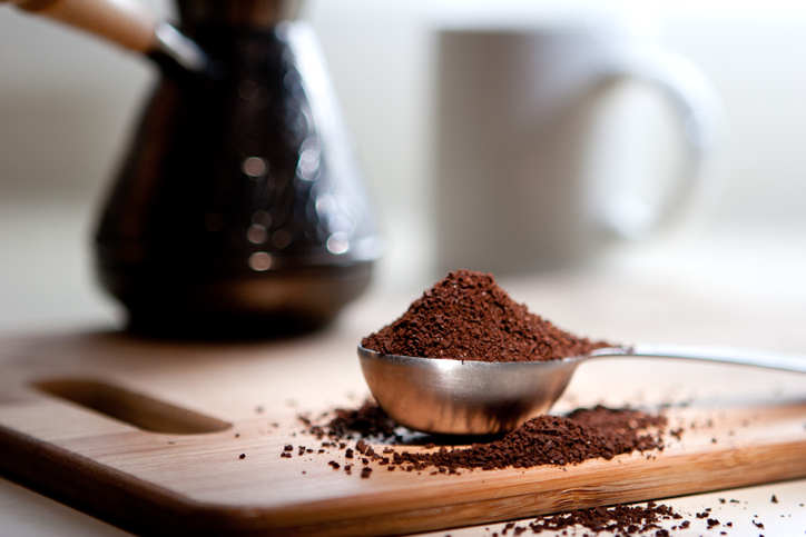 coffee grounds in measuring spoon on counter