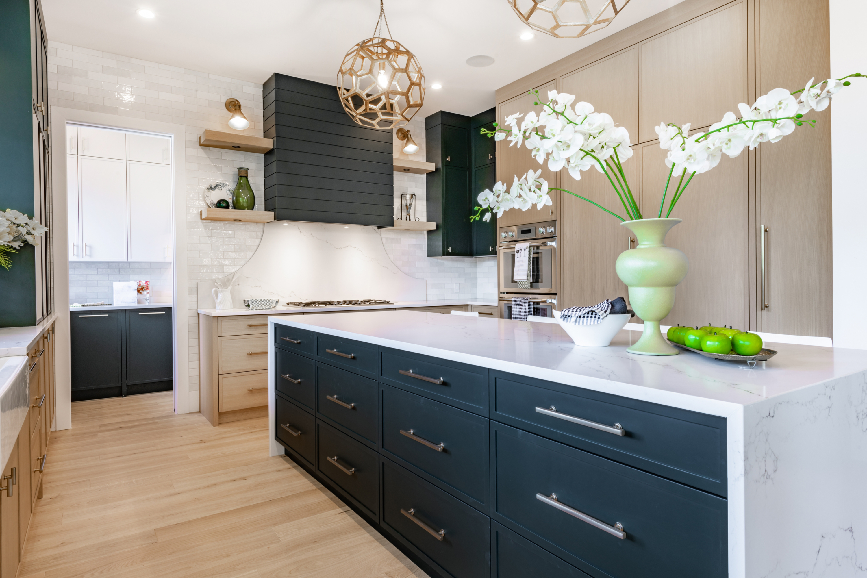 kitchen with navy blue cabinets and bold lighting