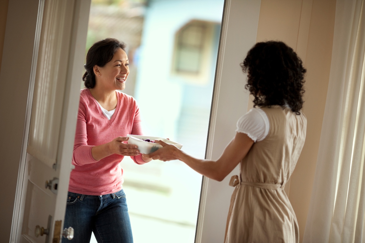 neighbor visiting homeowner with food