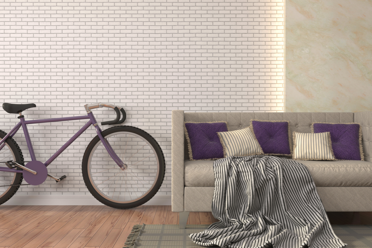purple bike and couch against white brick wall