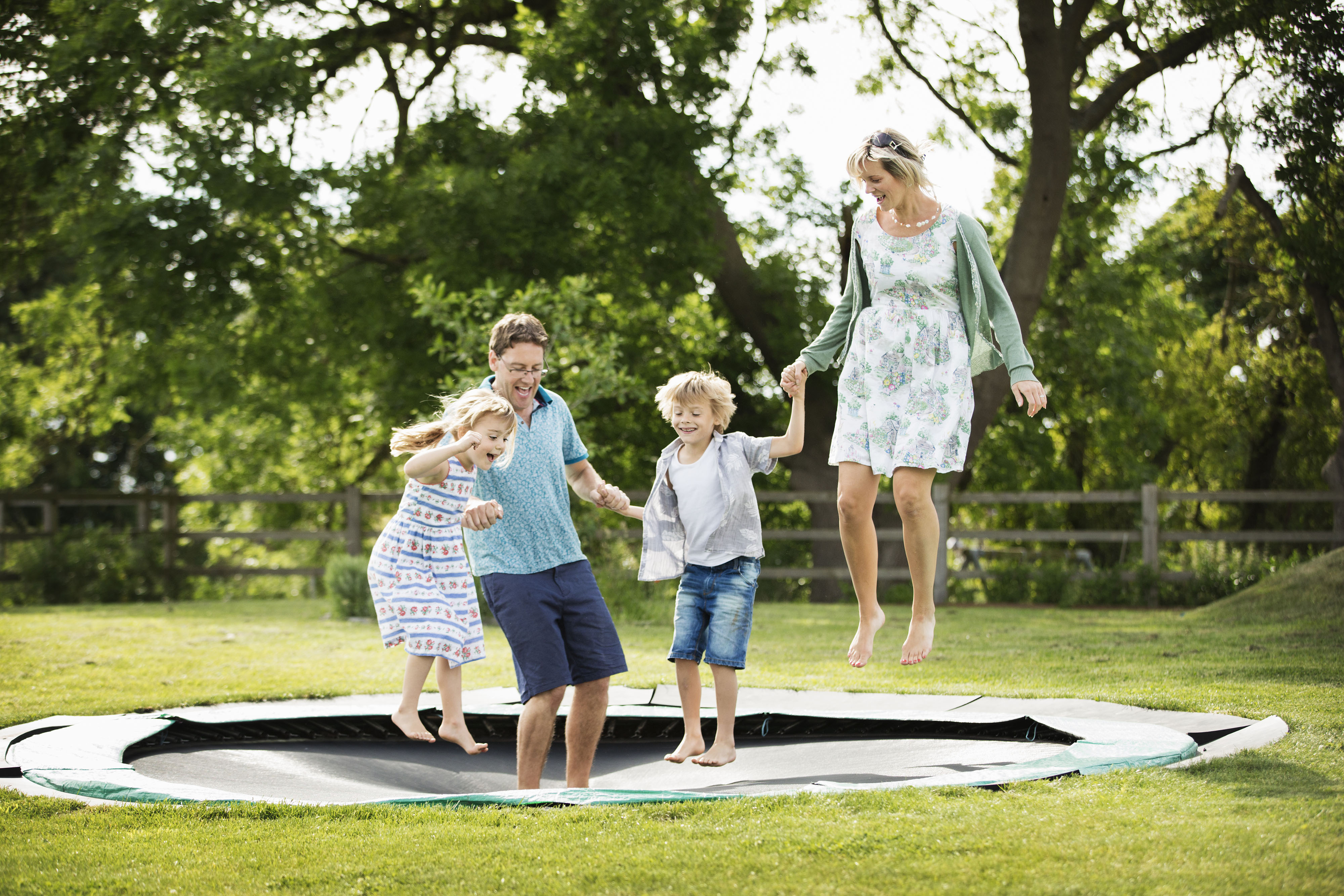 Family jumping on in-ground trampoline together