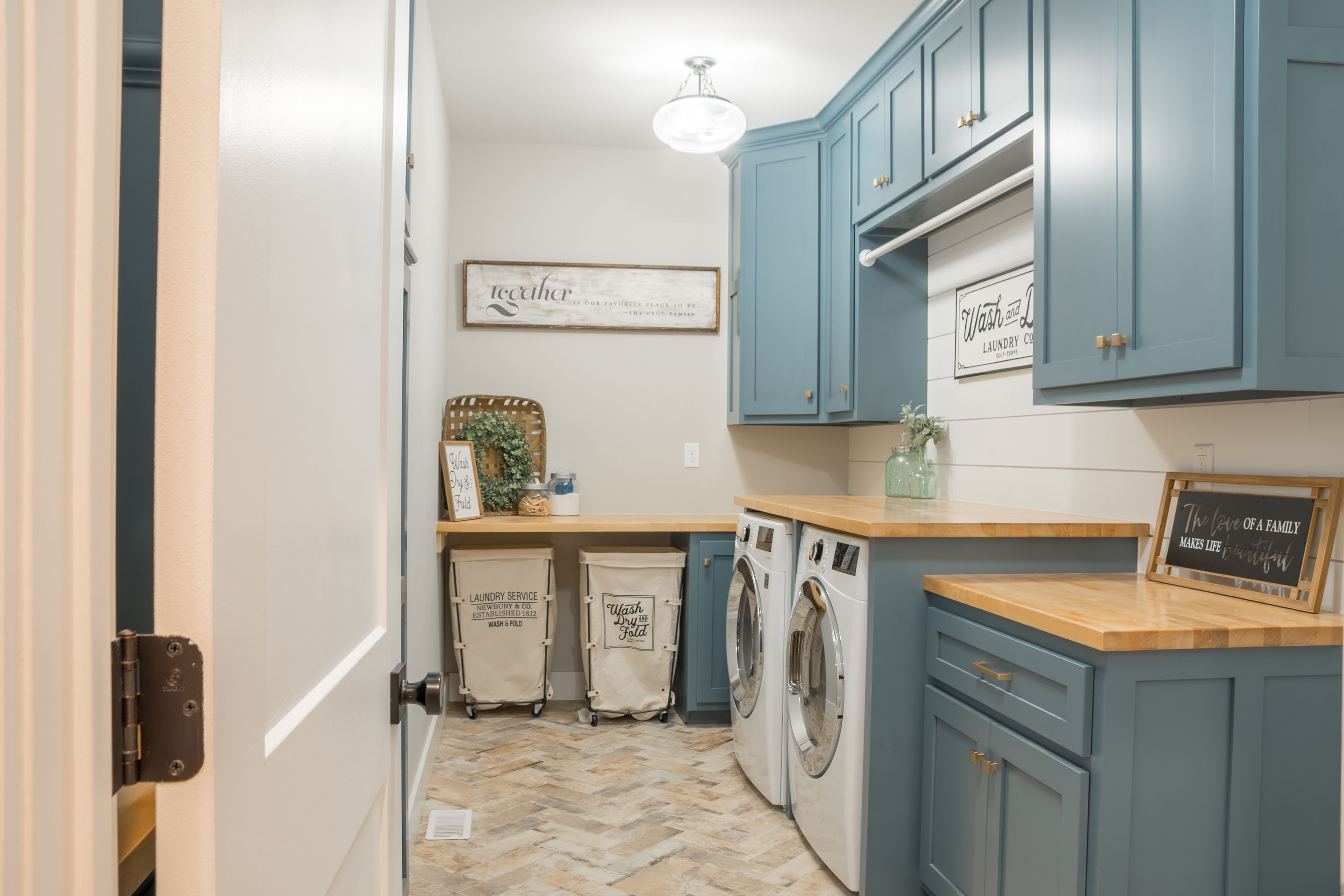 Farmhouse style laundry room with blue cabinets