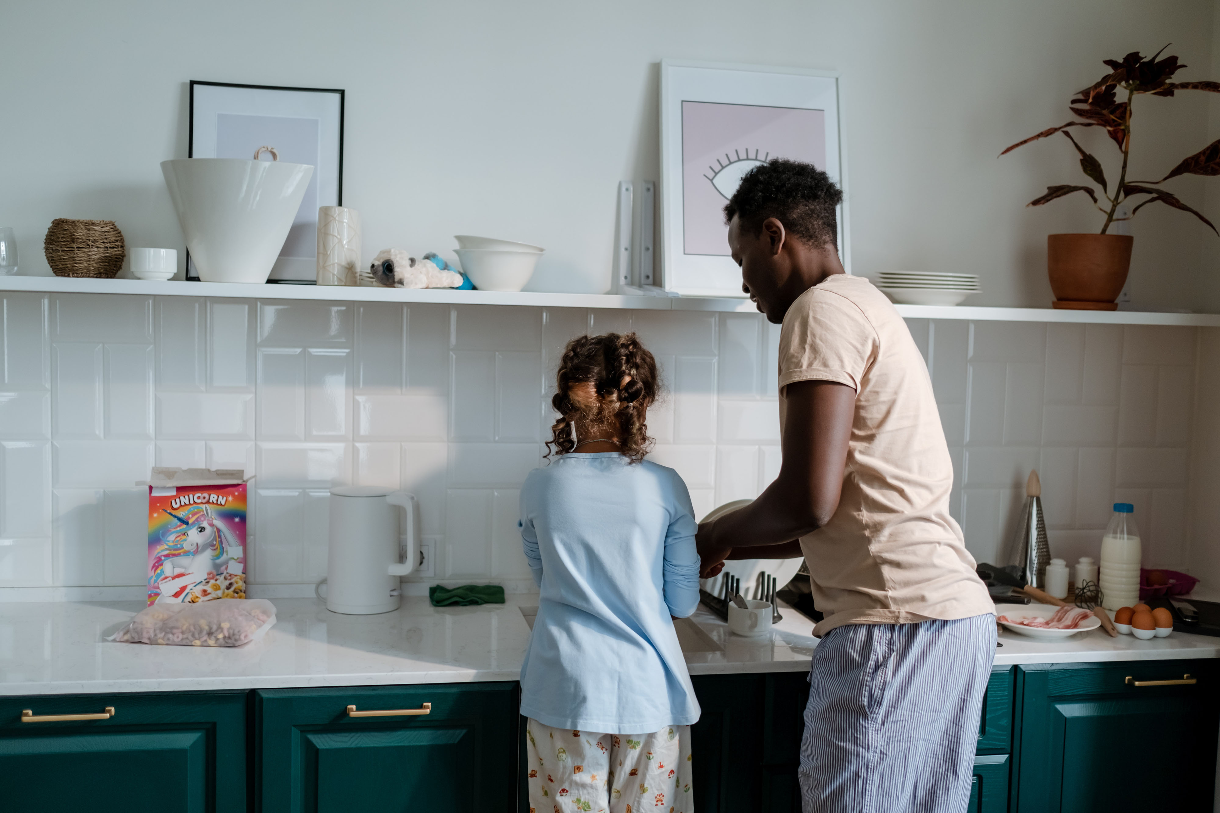 Father and daughter washing dishes together