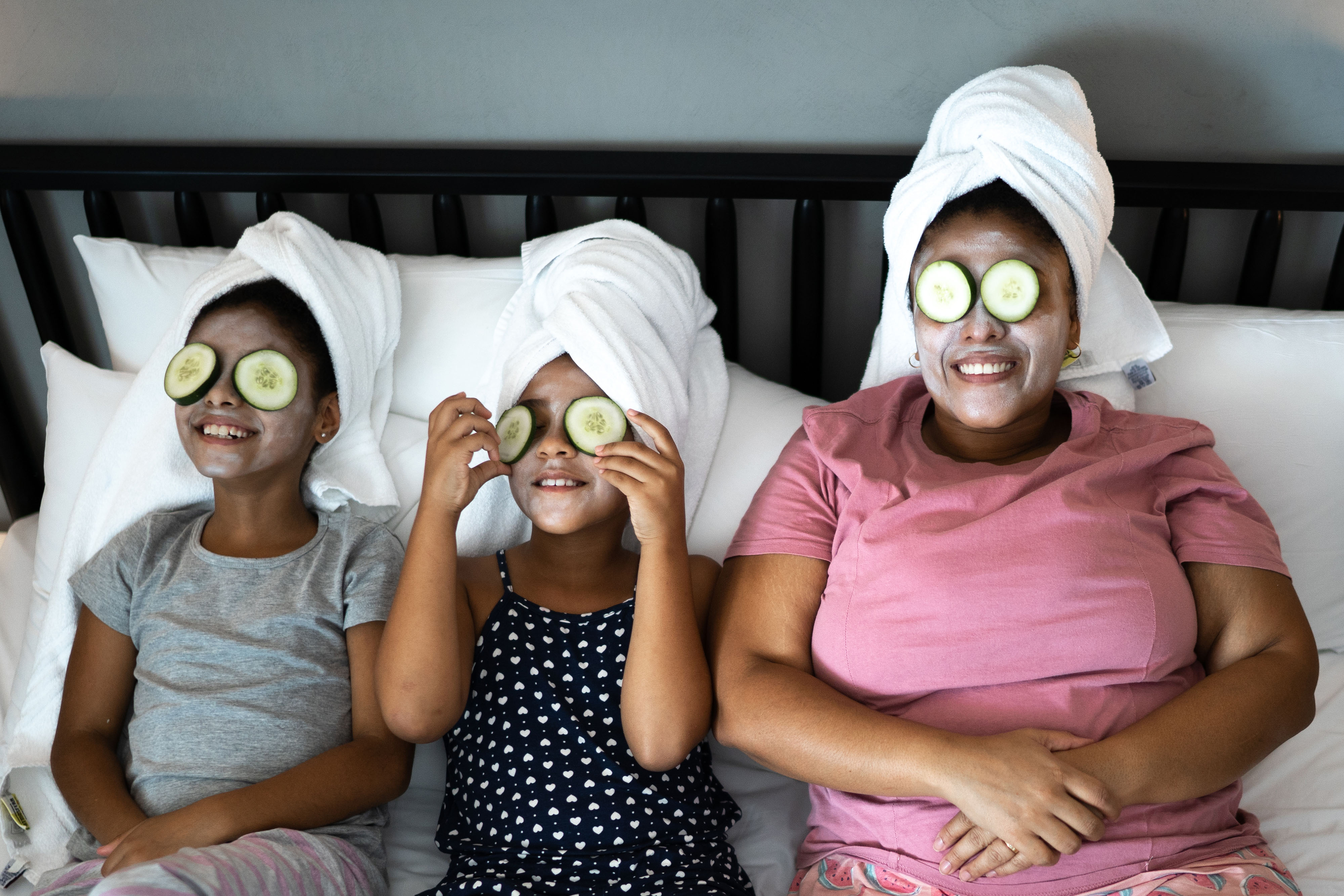 Mother and daughters in bed having a spa day