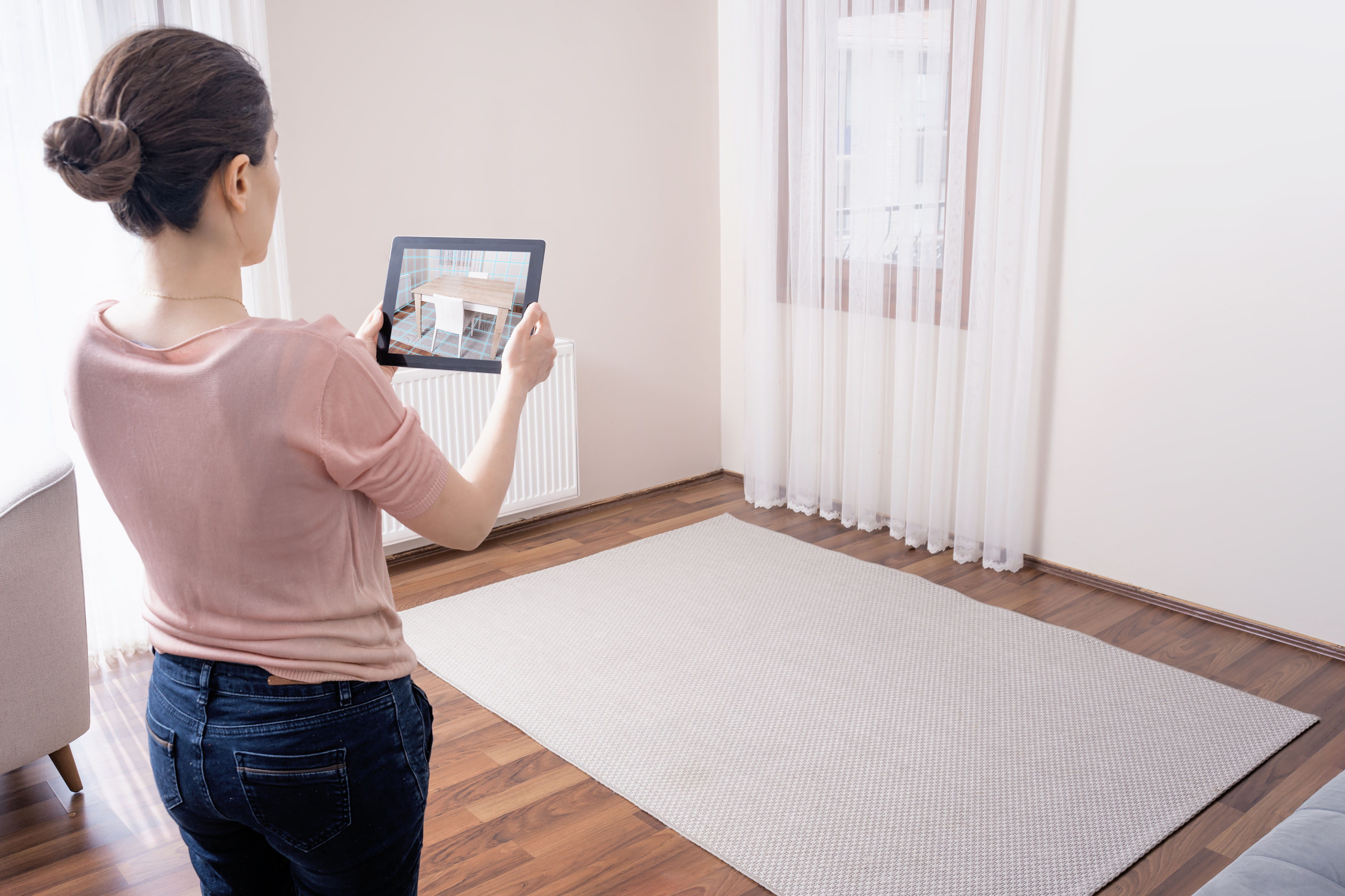 Woman using a home design app to visualize furniture in her home