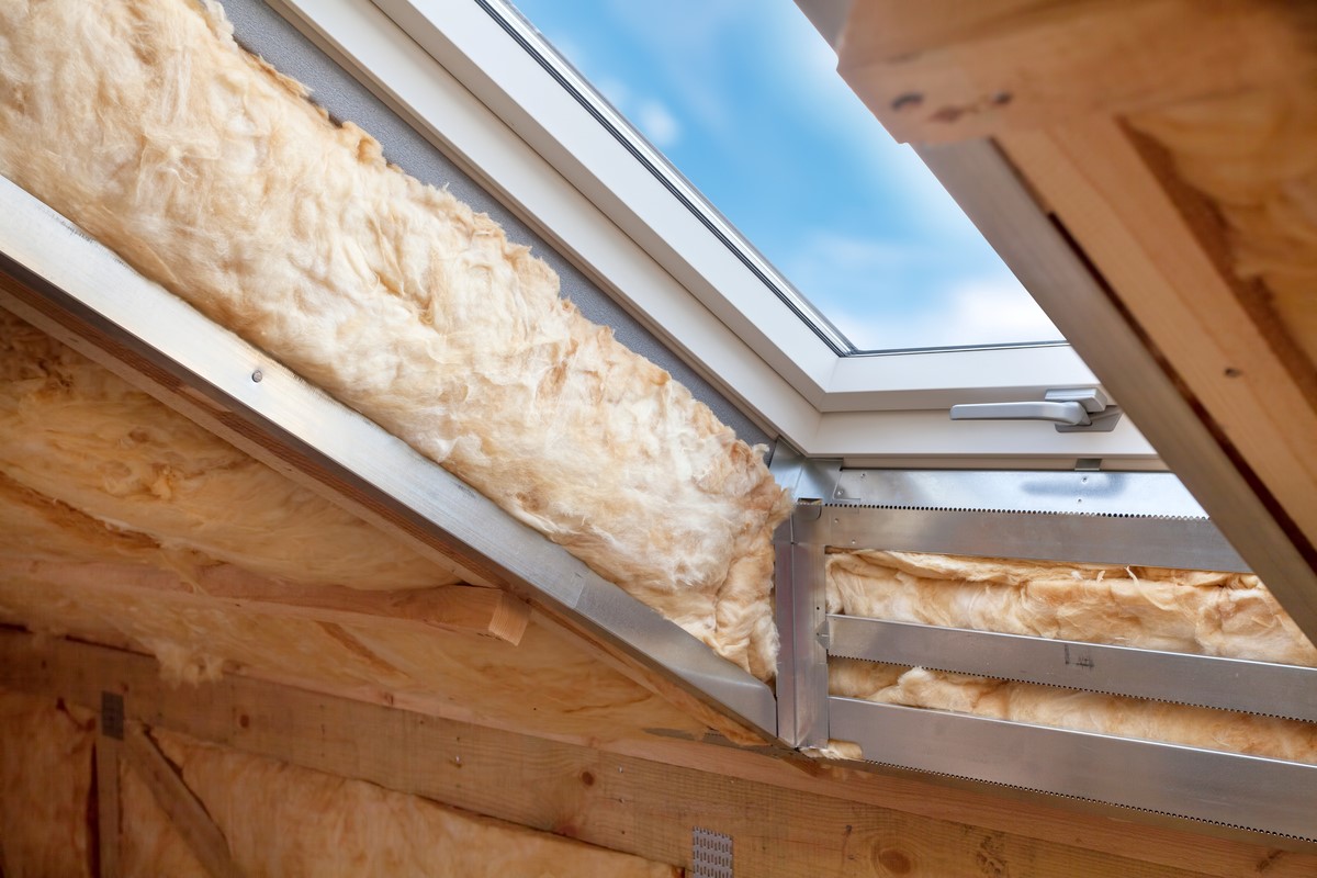 Attic skylight window with insulation surrounding it