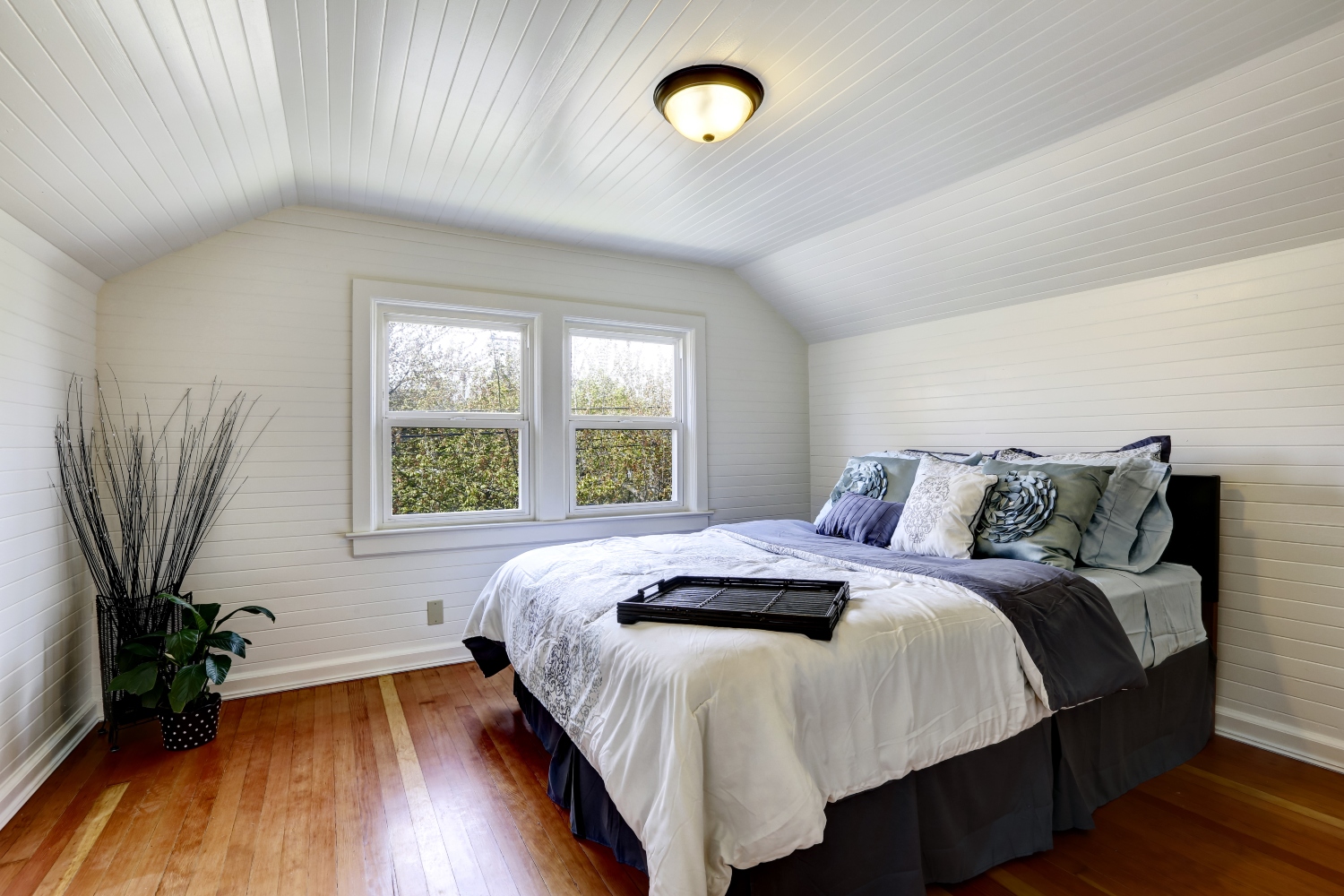 coastal bedroom design with all white interior and beadboard ceiling