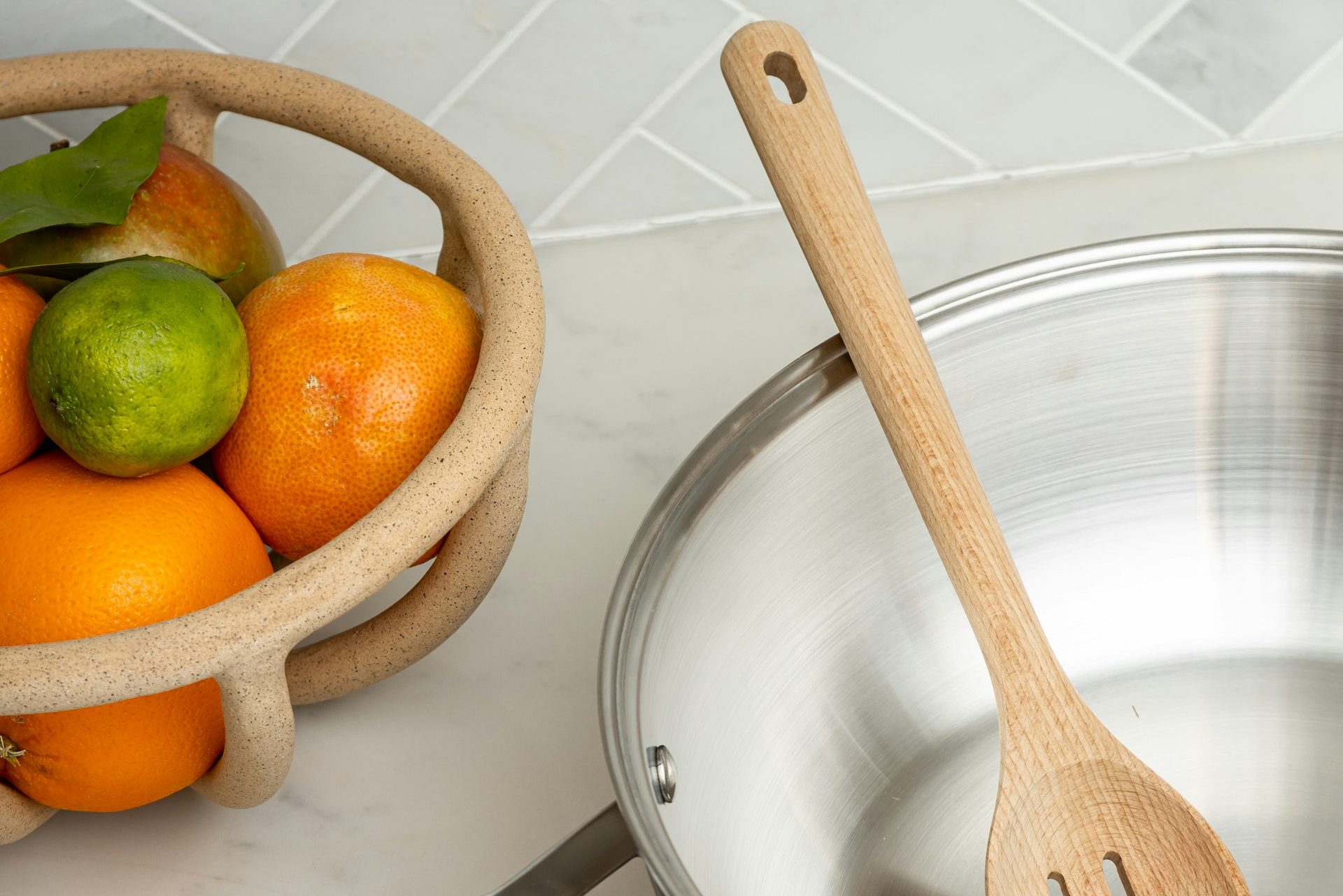 Stainless steel pan next to citrus fruit