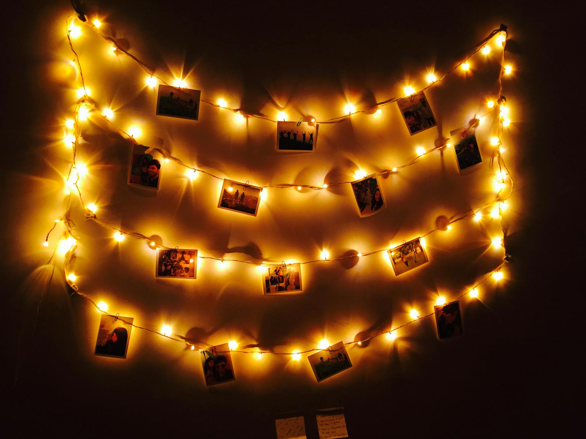 Fairy lights hung with photos on a wall