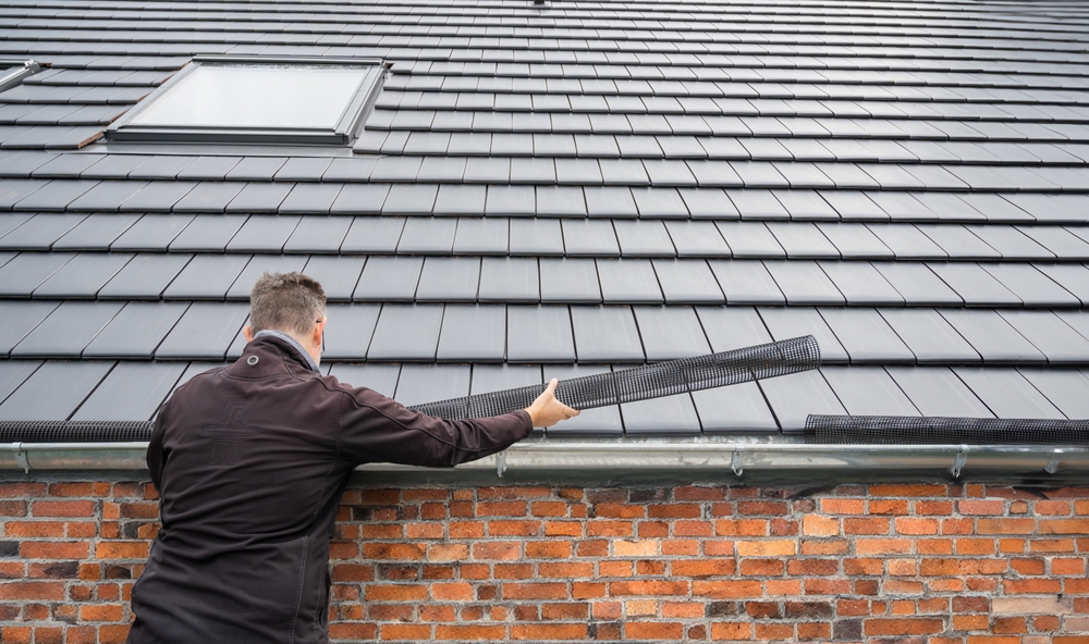 Man installing gutter guards on home