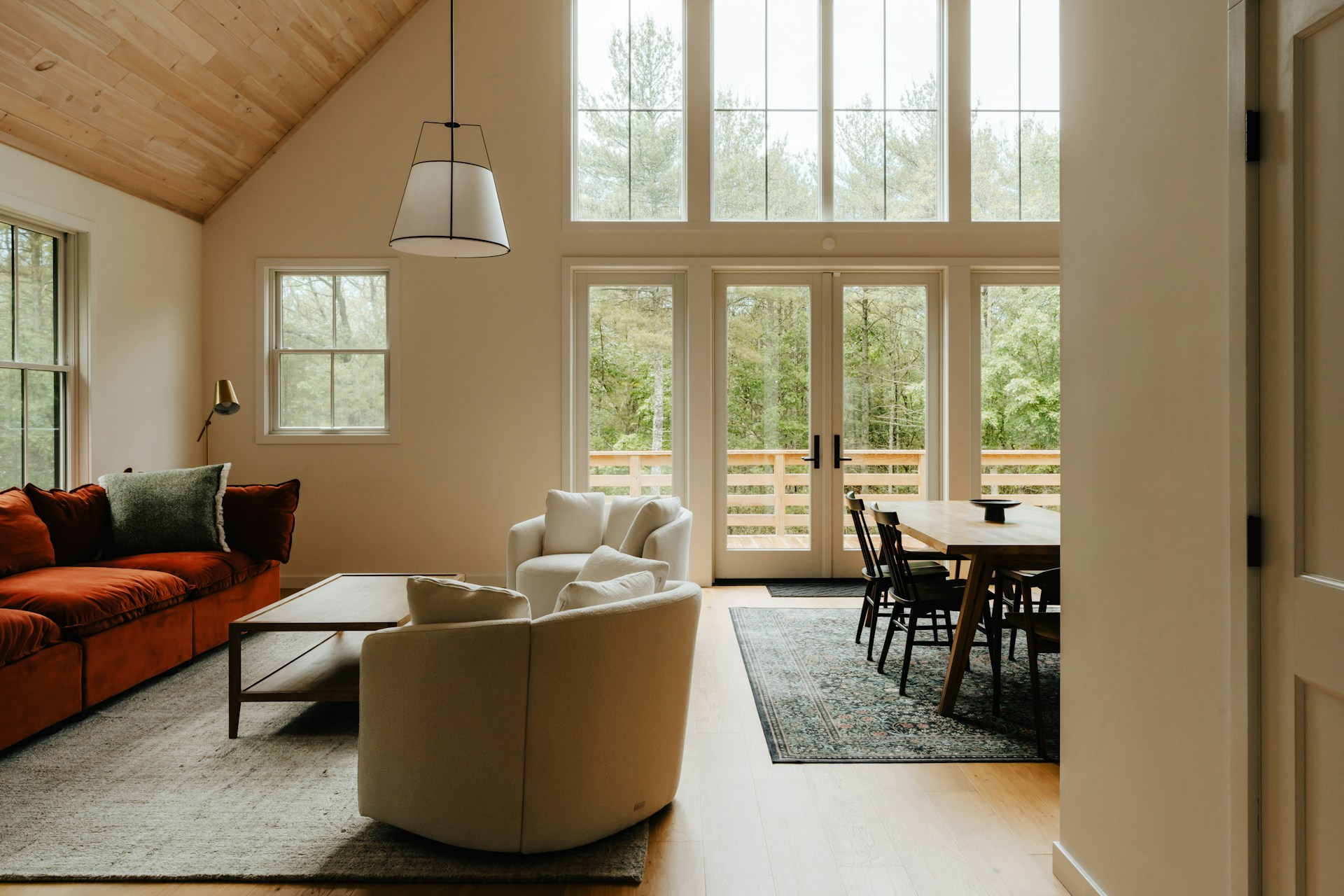 Modern living room with vaulted ceilings and large windows.