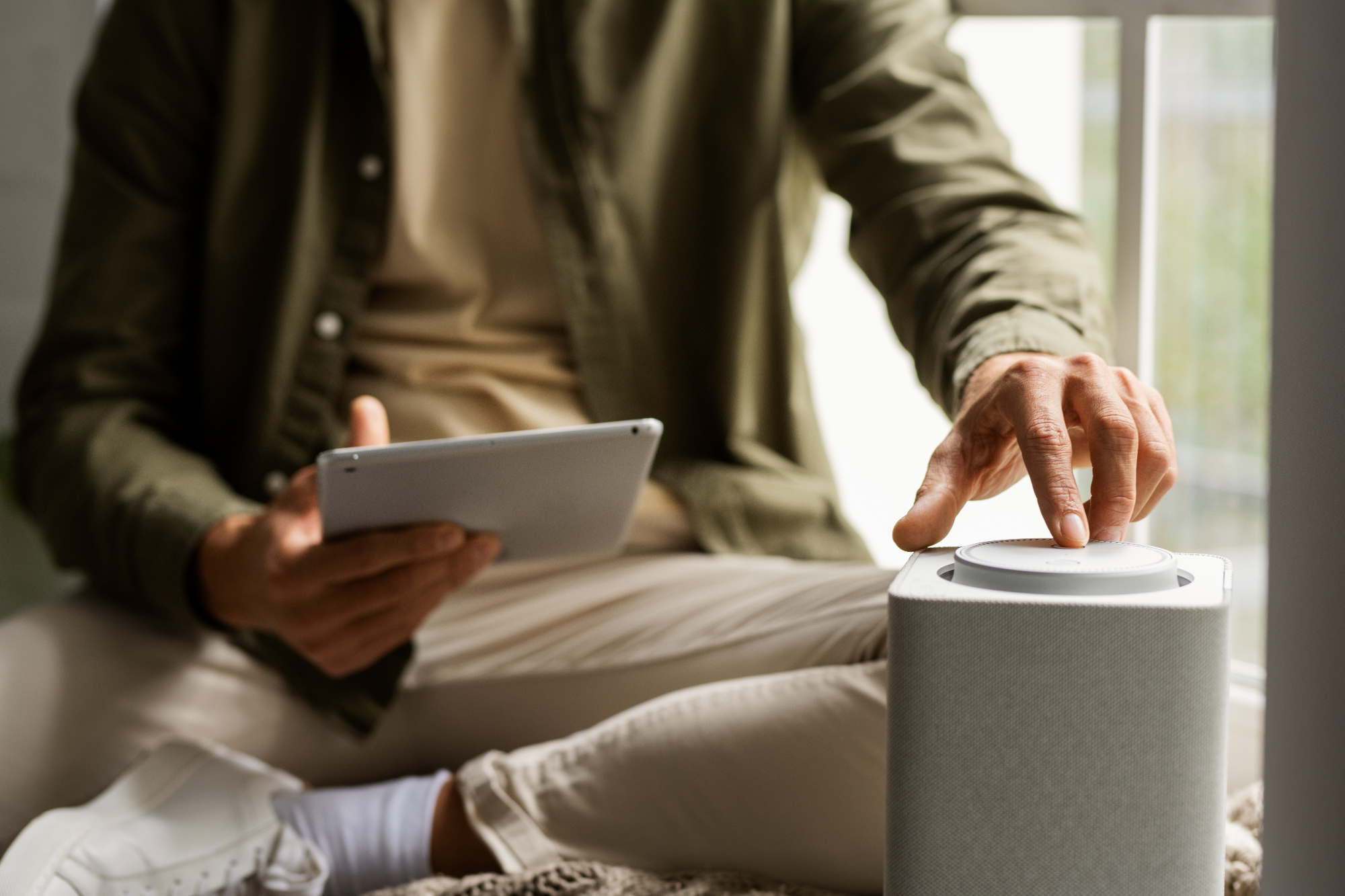 Man using tablet to operate air purifier