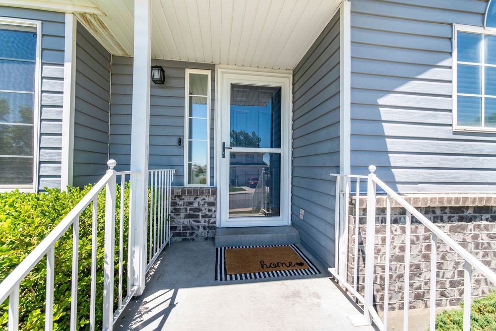 Front porch with entry door and storm door.
