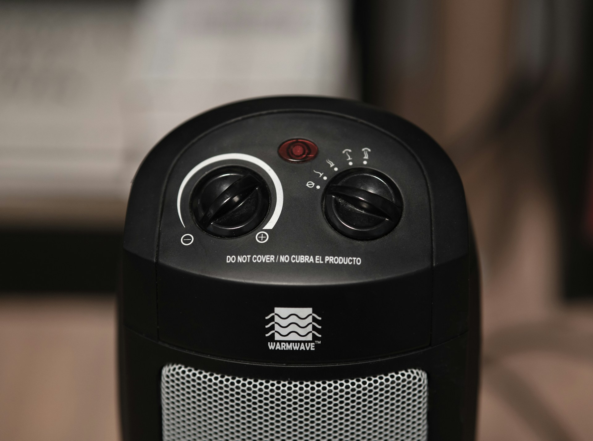 Black space heater with two knobs against unfocused background