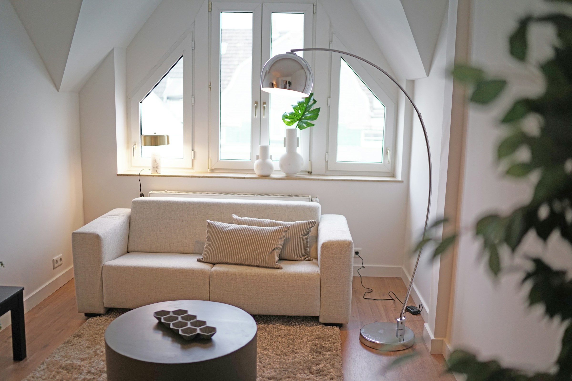 Small living room with light colored walls and furniture. How to make small spaces look bigger.