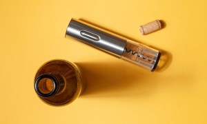 aop version 69 electric corkscrew made of gray metal  bottle and cork on a yellow background isolated hard light shadow