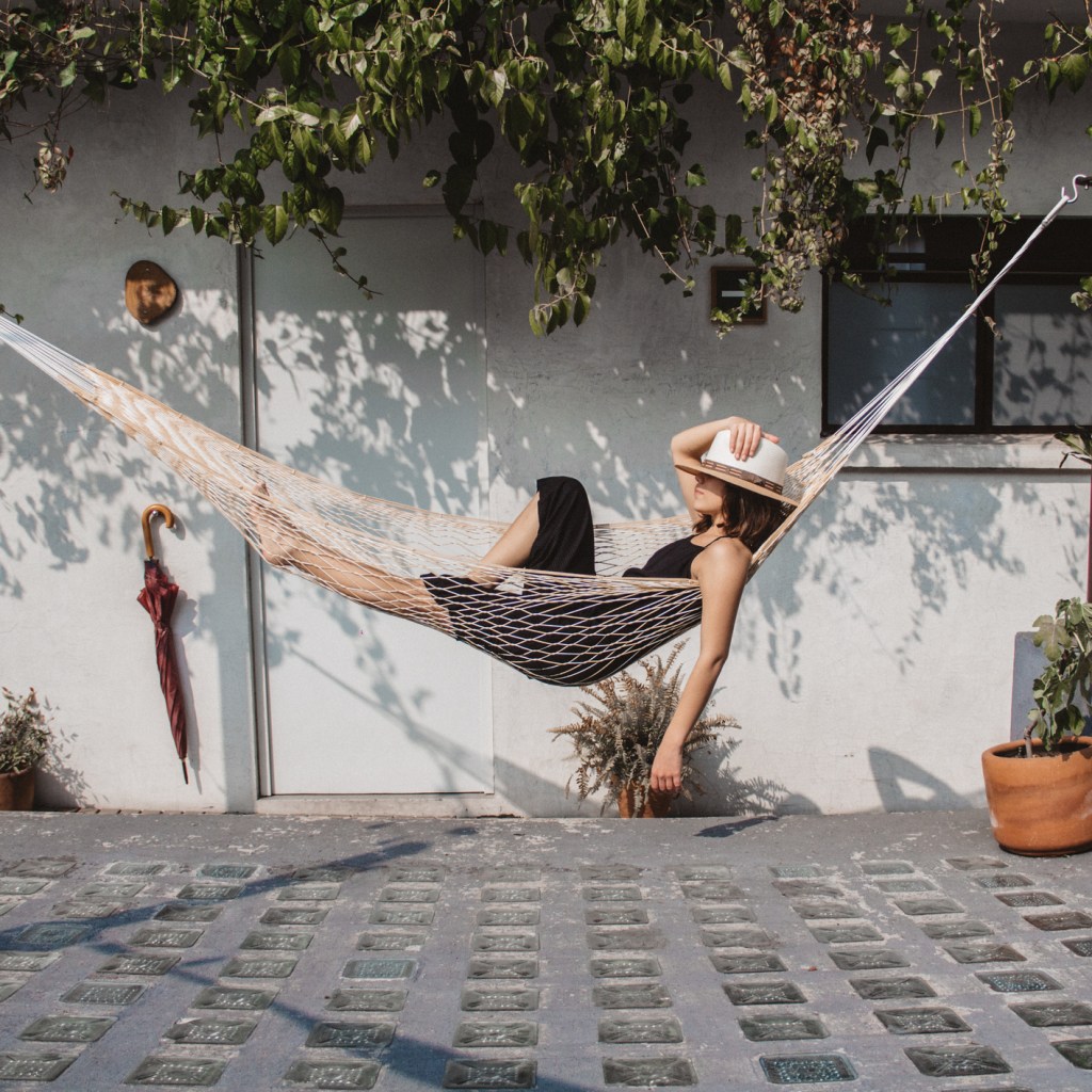 Woman swinging in a hammock on a patio