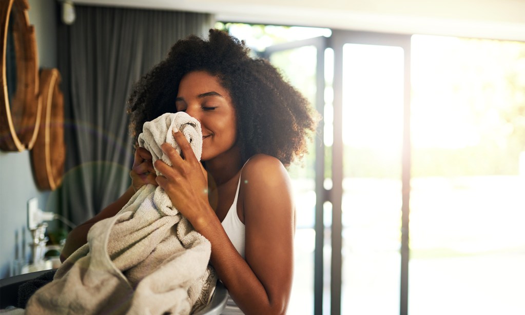 Woman smelling clean towel