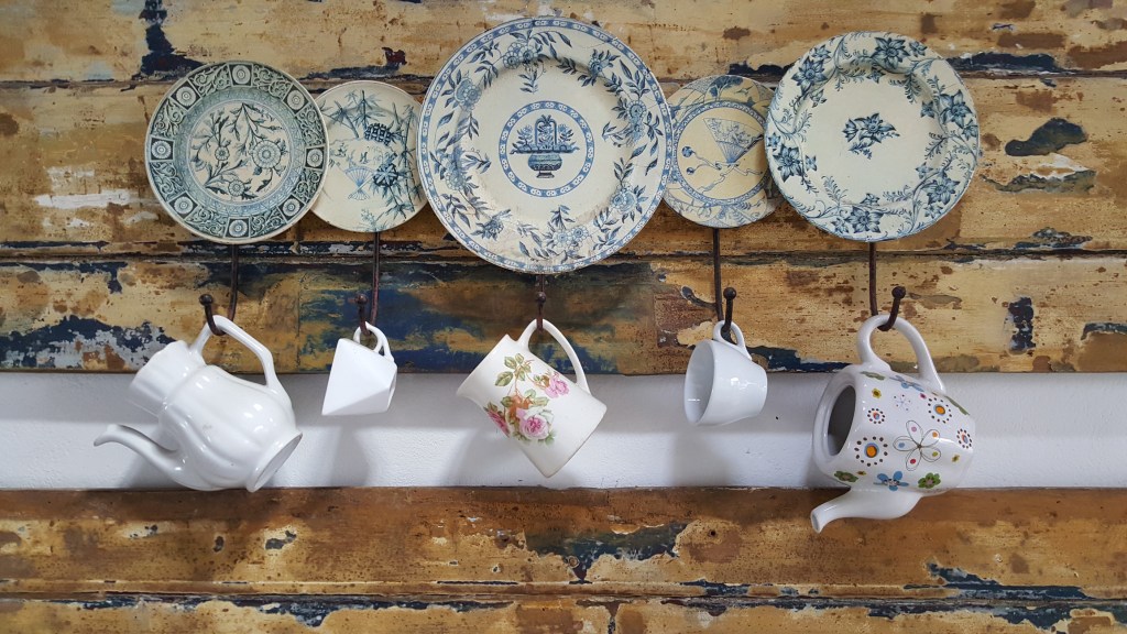 Cups and plate hanging on a wooden wall In the kitchen