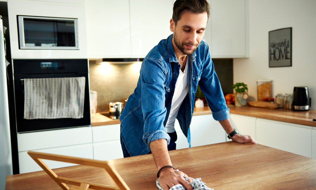 Man cleaning kitchen counter
