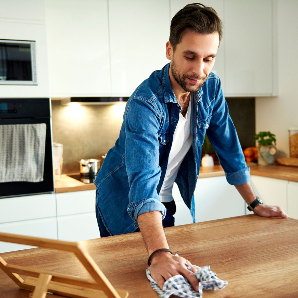 Man cleaning kitchen counter