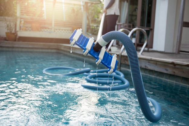 Pool vacuum sticking out of an outdoor pool