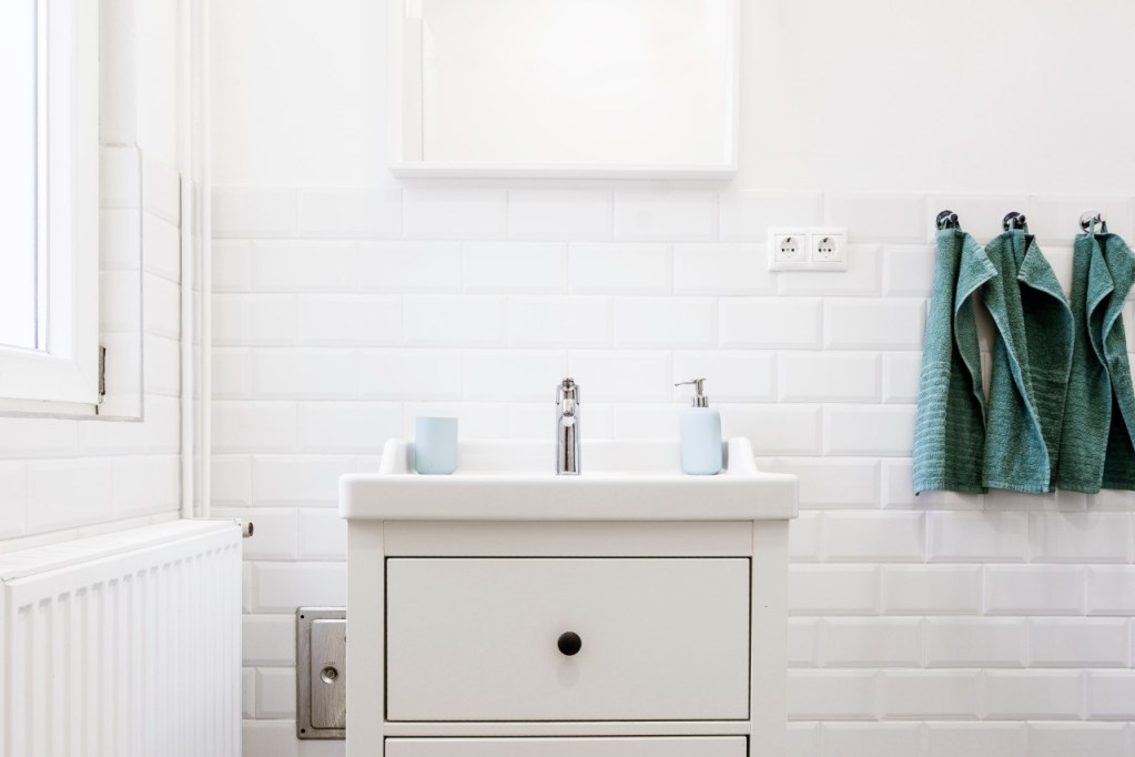 White bathroom sink with hanging towels