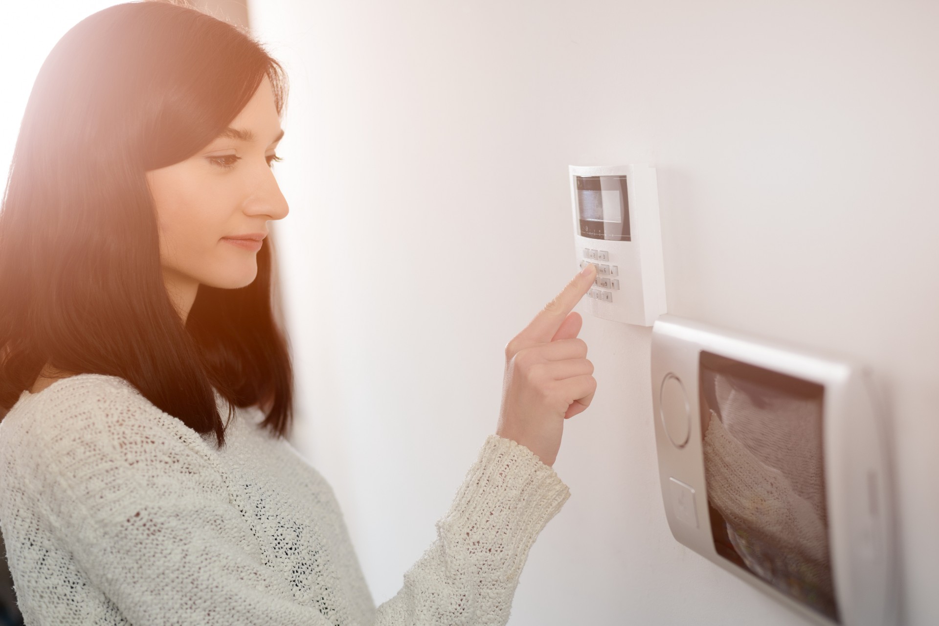 Woman using home security system