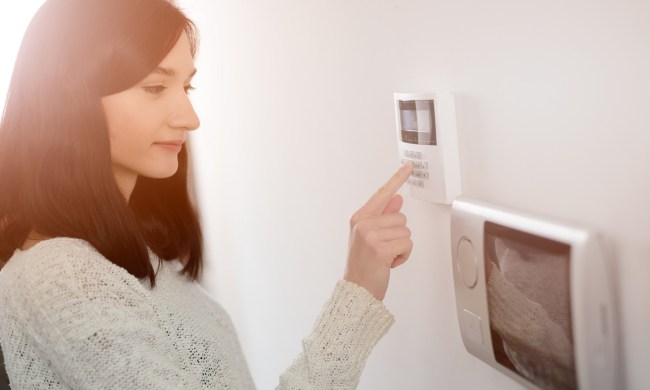 Woman using home security system