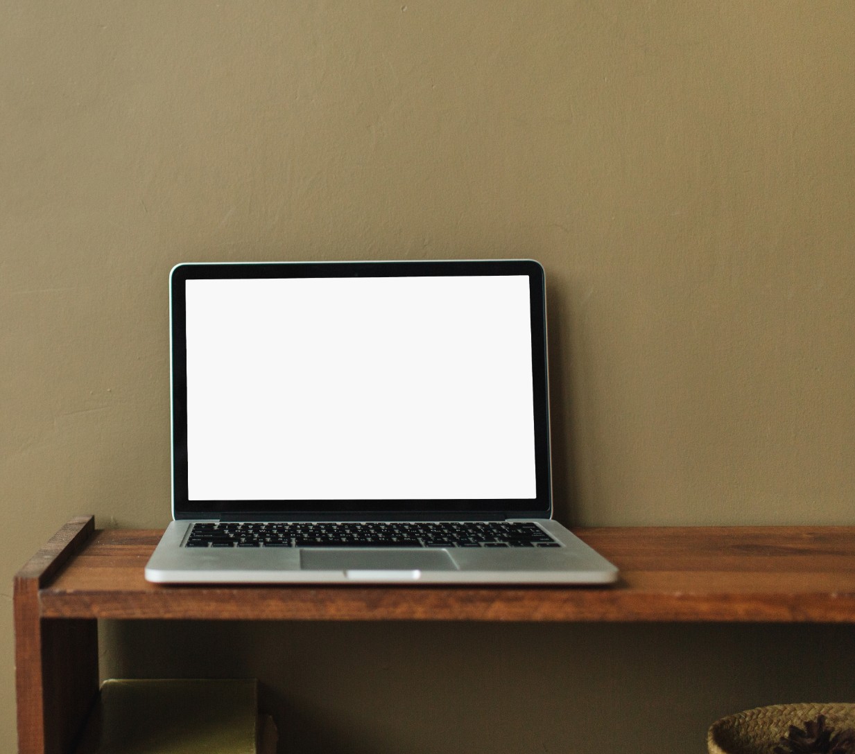 Laptop on desk with green wall