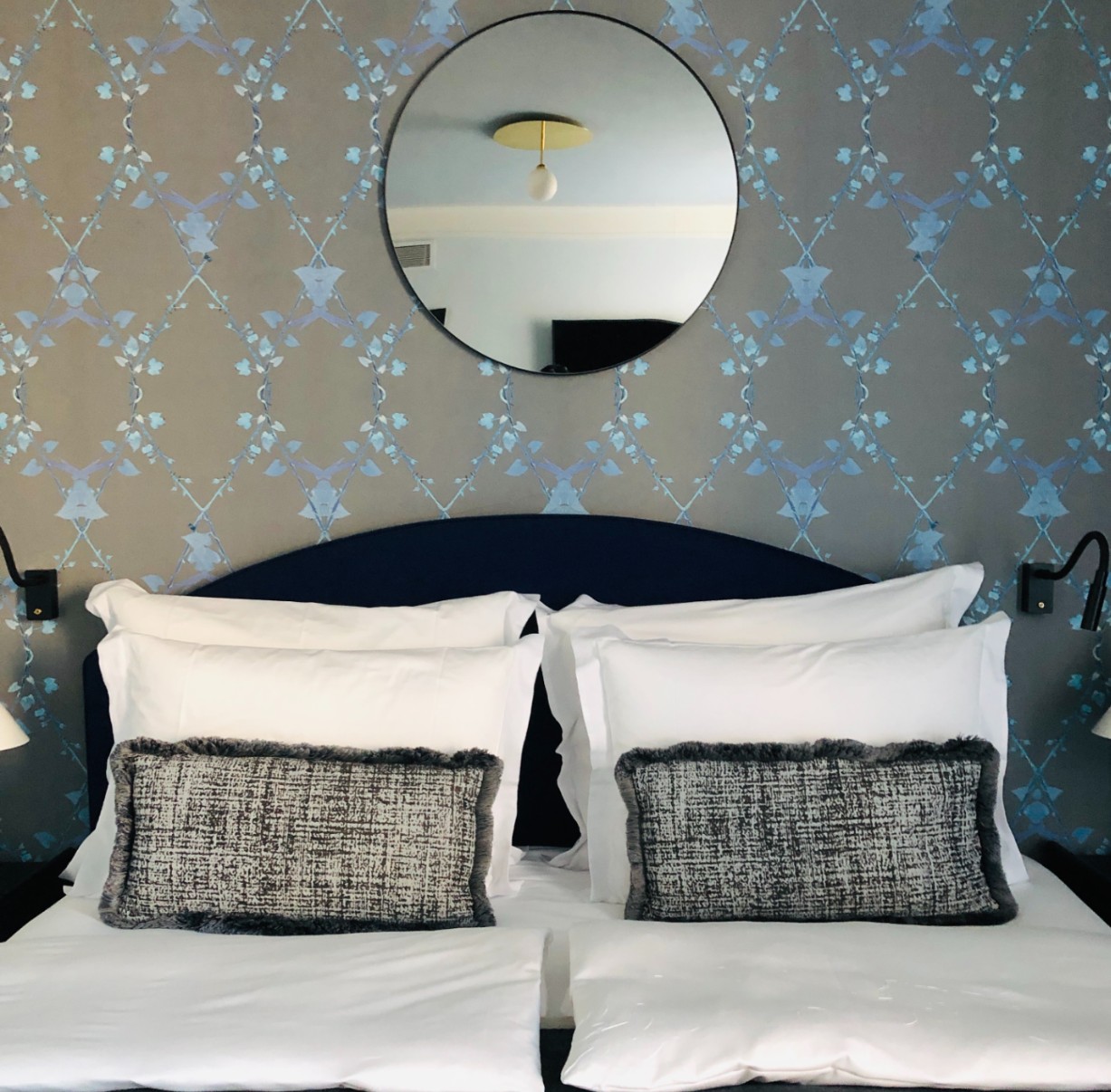 Bedroom with mirror and artistic wallpaper