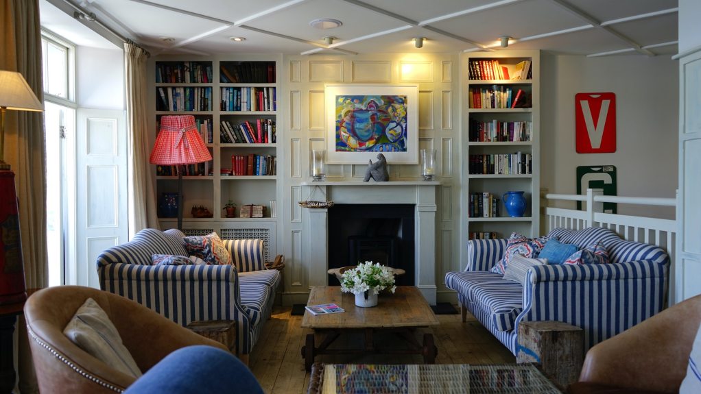 outdated colorful living room with fireplace and tall bookshelves