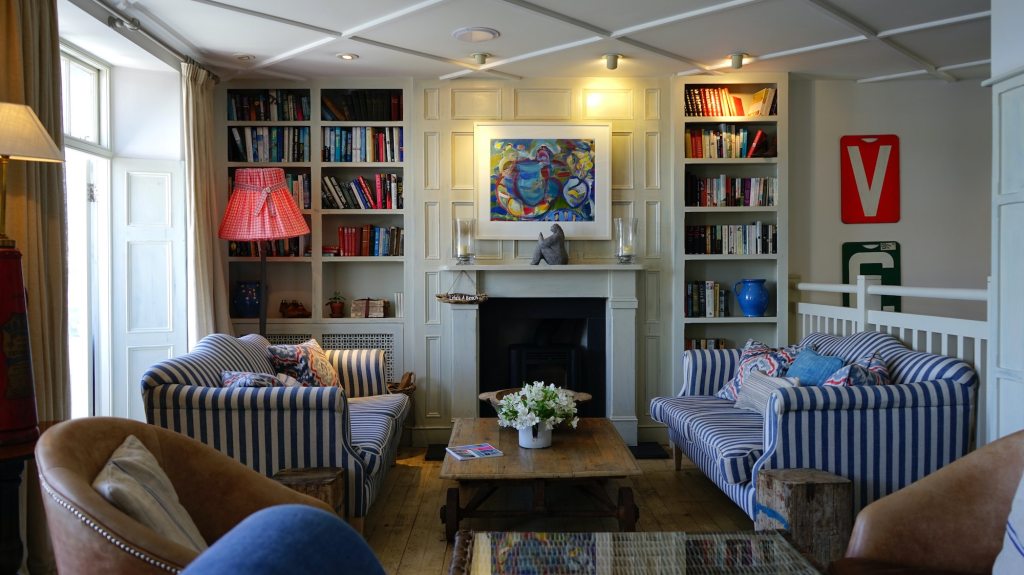 outdated colorful living room with fireplace and tall bookshelves