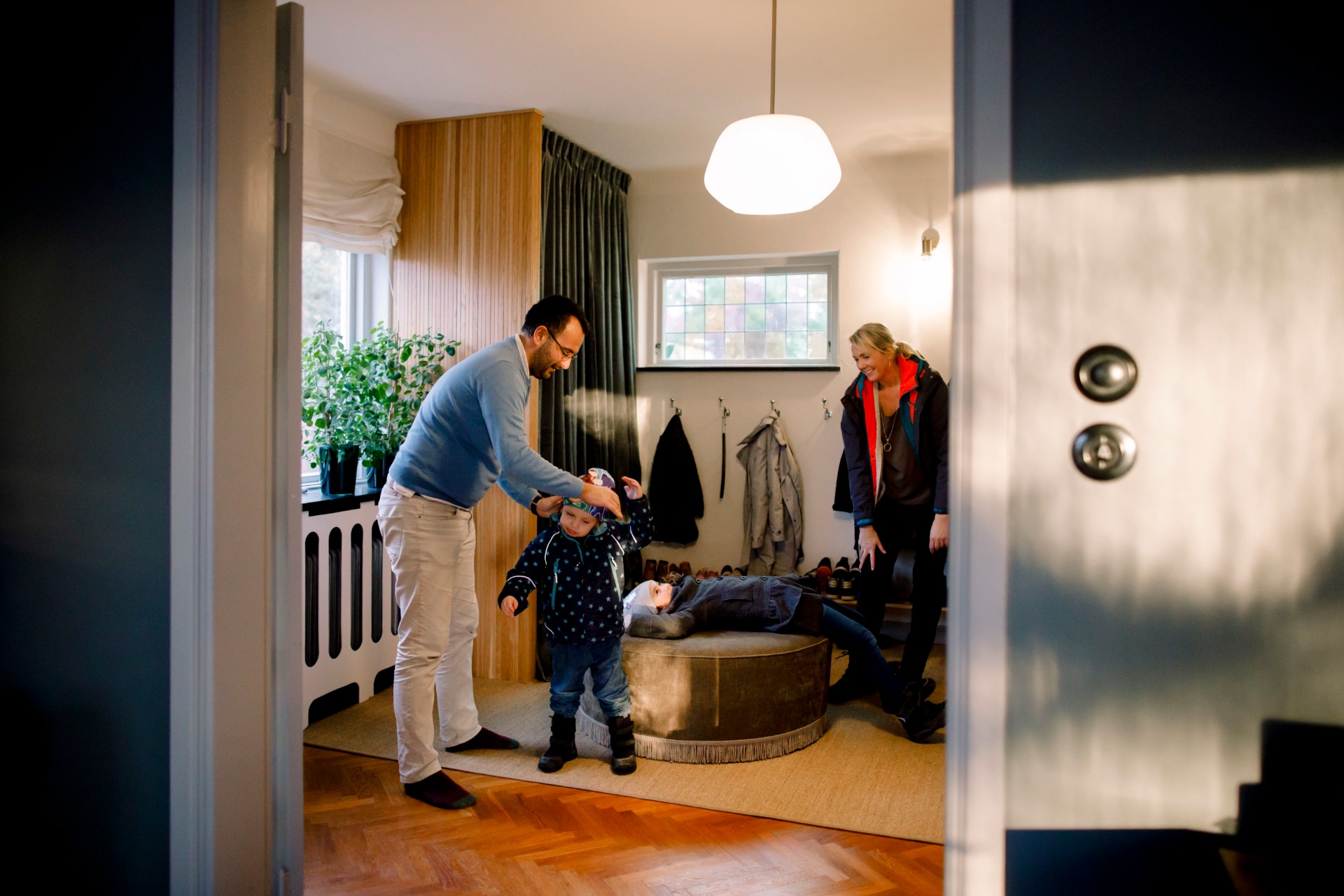 Mother and father putting coats on children