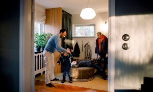Mother and father putting coats on children