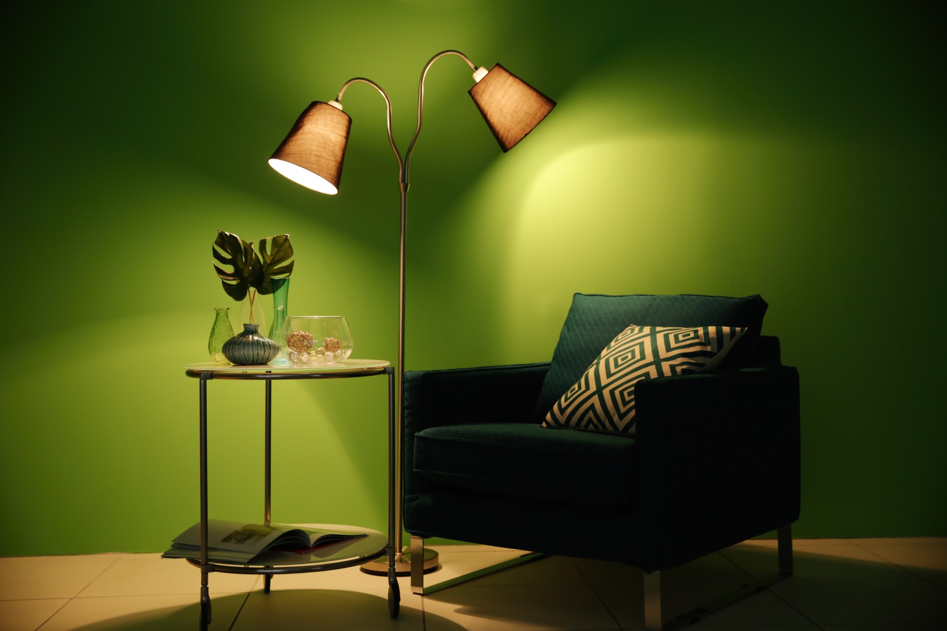Green chair in room with green walls and lamp