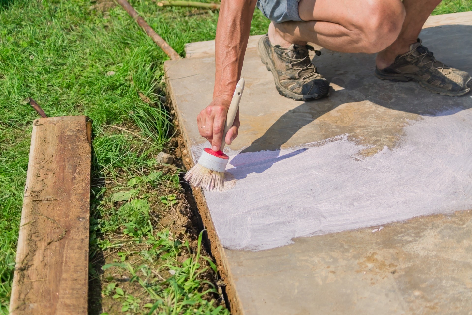 Person painting a concrete patio