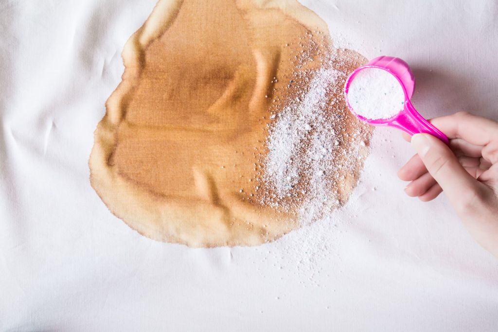 stain remover being sprinkled on large stain