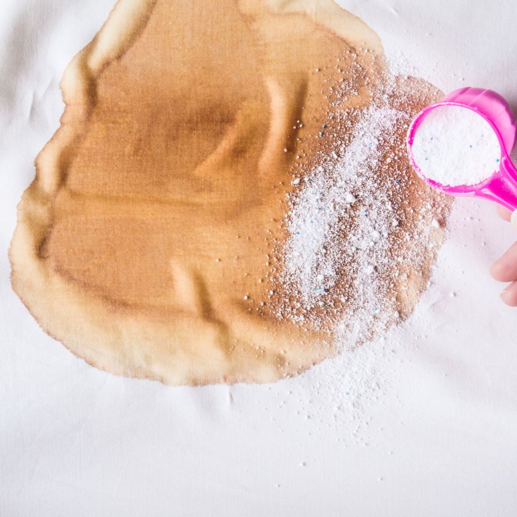 stain remover being sprinkled on large stain