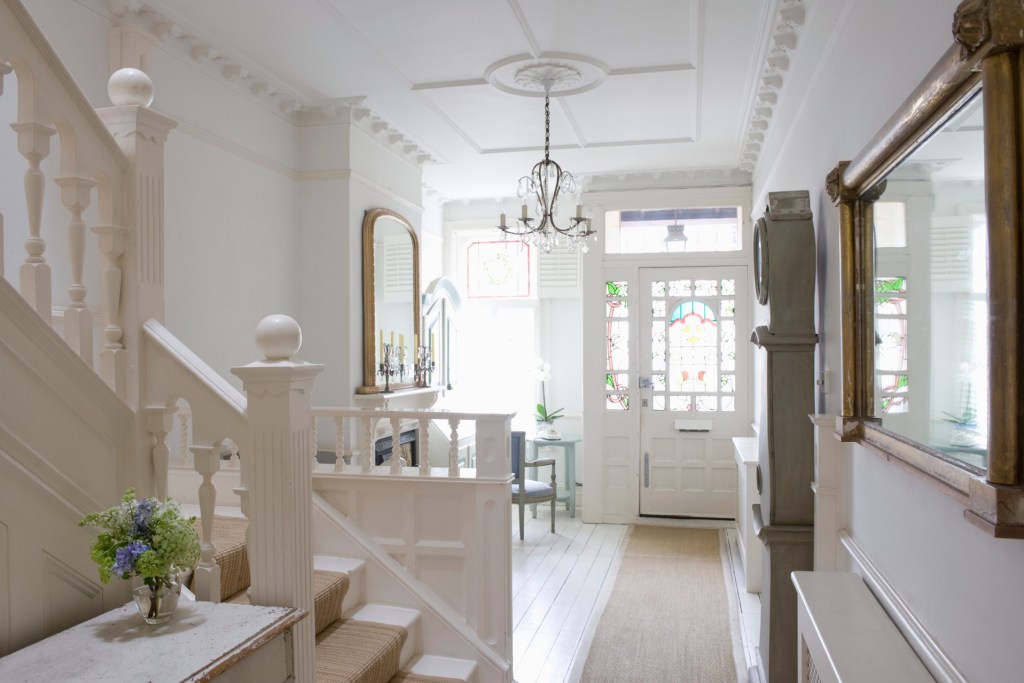 Sunny home with front door, rug, and stairs