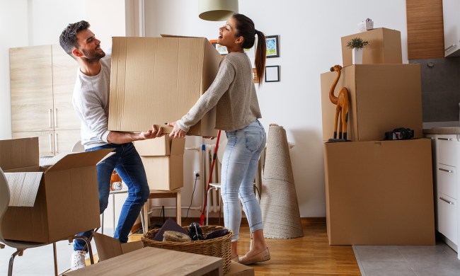 Man and woman moving big box in house